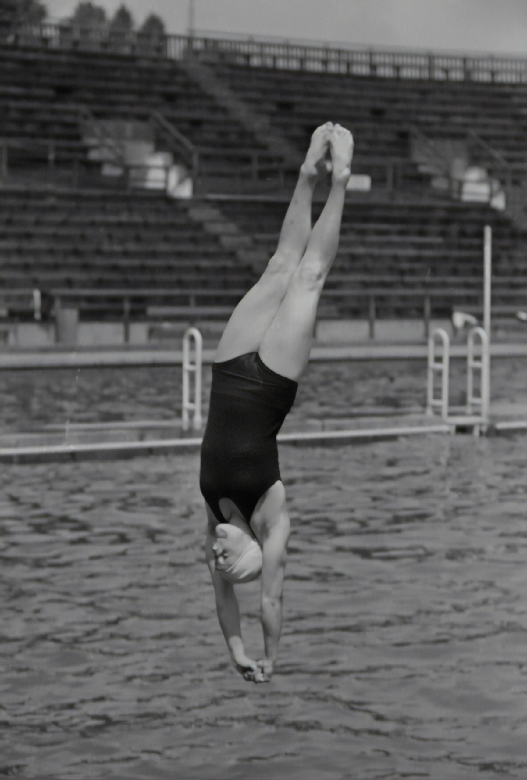 Fotografía en blanco y negro de una mujer saltando de cabeza en una piscina olímpica, símbolo de la segunda generación abierta al mundo y al deporte